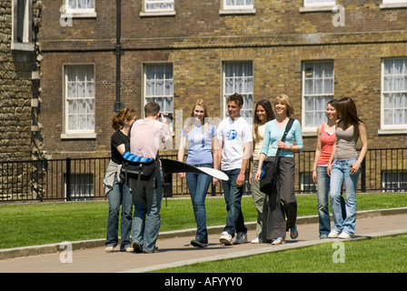 Kameramann bei der Arbeit macht Fotos und Assistent mit Reflektor filmt Gruppe von Menschen 2006 Freizeitkleidung beim Spaziergang auf College Green Westminster London UK Stockfoto