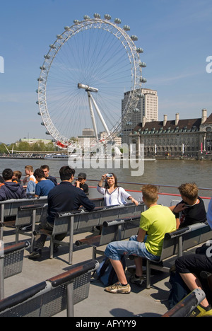 Themse tour Boot Fluggäste einsteigen und ihre Sitze, die für die Besichtigung beginnt am Westminster Pier London Eye über England Großbritannien Stockfoto