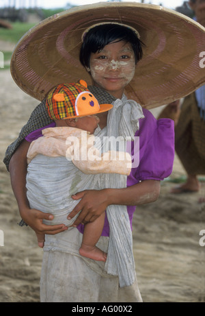 Junges Mädchen mit Tanaka Rinde vorbei auf Gesicht sorgen für ihr jüngerer Bruder in Birma/Myanmar Stockfoto