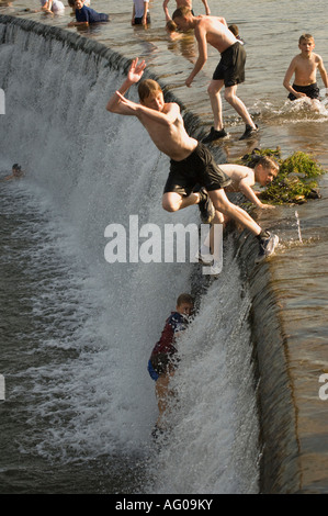 Jugendliche und Kinder freuen sich über Fluss während der heißen Sommertage in Denton Hause Weir Carlisle UK Stockfoto