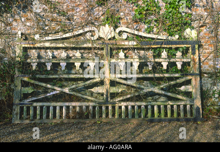 Alte verzierte Holztor Brick Wand gelehnt Stockfoto
