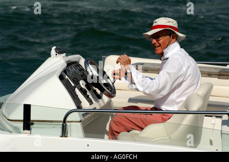 ein Herr mittleren Alters an der Spitze einer Luxusyacht Motoryacht in Cowes auf der Isle Of Wight während der Cowes week Stockfoto