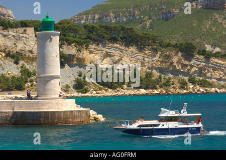 Boot in Cassis Provence Frankreich Marina kommen und vorbei an den Leuchtturm.  Hügel im Hintergrund. Das Wasser ist türkis. Stockfoto