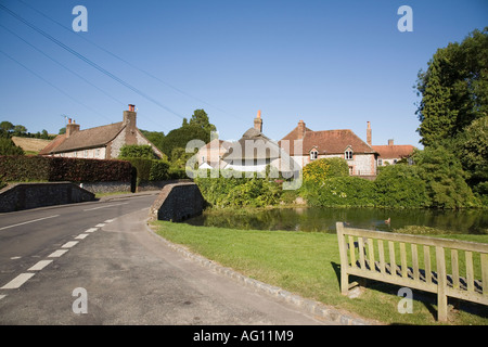 Kleine Straße Brücke und Grün durch Dorfteich mit alten Cottages über im Sommer. Singleton West Sussex England UK. Stockfoto