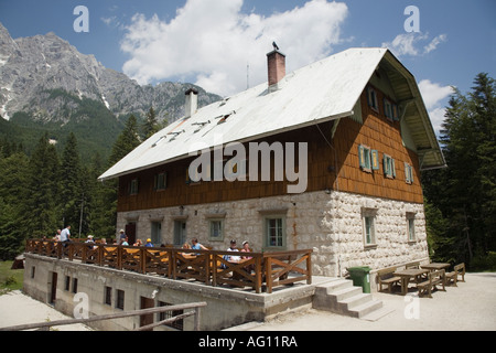 Berg Hütte Aljazev Dom mit Menschen im "Triglav National Park" in "Julischen Alpen" im Sommer draußen sitzen. Mojstrana Slowenien Stockfoto