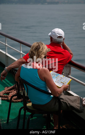 Älterer Mann und Frau Touristen an Bord einer Fähre, Gardasee, Italien, Europa, mit Blick auf die Karte der Gegend Frau Stockfoto