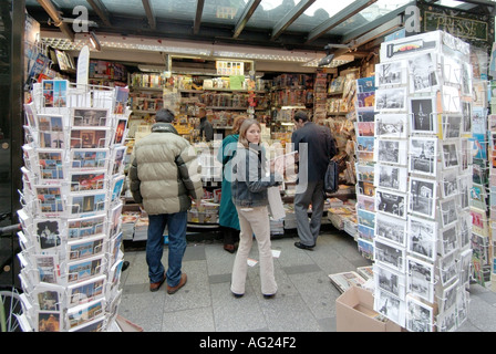 Paris Leute einkaufen bei typischen Karte Postkarte Zeitschrift und Zeitung Kiosk Stall auf Pflaster mit Anbieter Kunden Frankreich Stockfoto