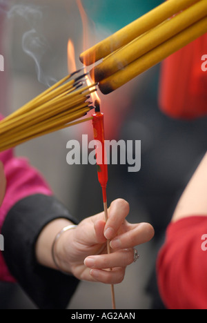 Anbeter Beleuchtung Räucherstäbchen während Lunar New Year Feiern im Wong Tai Sin Tempel, Kowloon. Hongkong, China Stockfoto