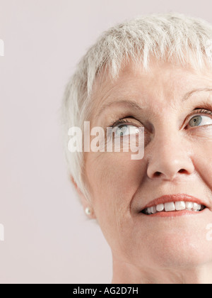 Frau mittleren Alters, die auf der Suche auf und Lächeln auf den Lippen, Nahaufnahme Stockfoto