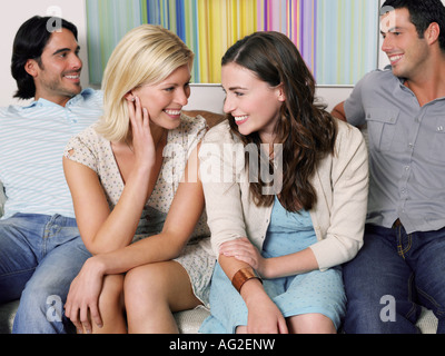 Gruppe junger Leute sitzen in Reihe auf sofa Stockfoto