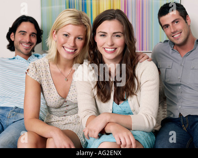Gruppe junger Leute sitzen in Reihe auf Sofa, Porträt Stockfoto