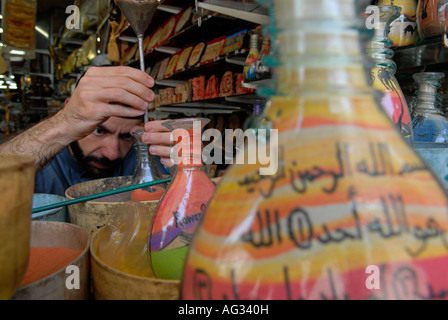 Jordanische Mann fügt farbige Sand eine dekorierte Flasche mit bunten Sand Felsen gefüllt, die in Petra in einem Souvenirshop in Amman Jordanien gefunden wird Stockfoto