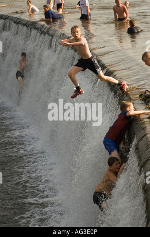 Jugendliche und Kinder freuen sich über Fluss während der heißen Sommertage in Denton Hause Weir, Carlisle, UK Stockfoto