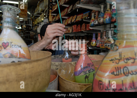 Jordanische Mann fügt farbige Sand eine dekorierte Flasche mit bunten Sand Felsen gefüllt, die in Petra in einem Souvenirshop in Amman Jordanien gefunden wird Stockfoto