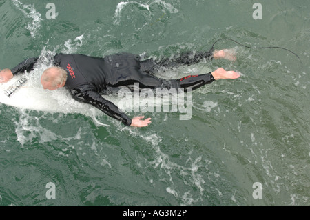 Ein Mann paddelt auf einem Surfbrett. Stockfoto