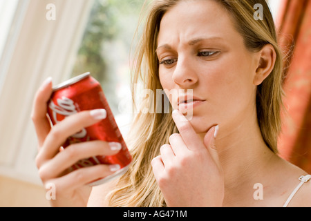 Mädchen lesen auf Rückseite des Cola-Dose Stockfoto