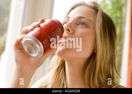 Mädchen trinken Cola aus Zinn Stockfoto