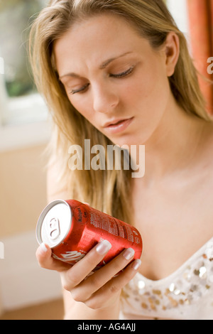 Mädchen lesen auf Rückseite des Cola-Dose Stockfoto