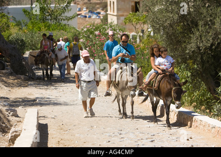 Touristen fahren Esel Sumit der Akropolis in der Stadt Lindos auf der griechischen Insel Rhodos Stockfoto