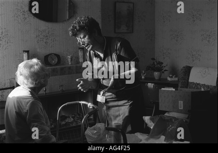 Bezirk Krankenschwester im Gespräch mit einem Patienten während ihr Besuch in ihrem Hause, East London, UK. Stockfoto