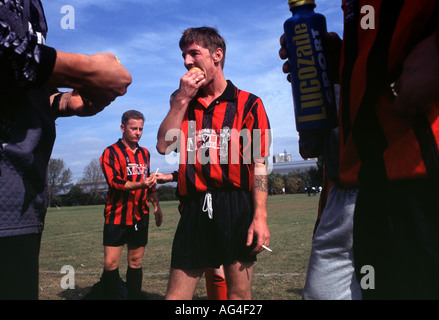 Ein Sonntag Kneipe Fußball Ligamannschaft genießen Sie Zigaretten und Orangen in der Halbzeitpause auf Hackney Sümpfe, East London, UK. Stockfoto