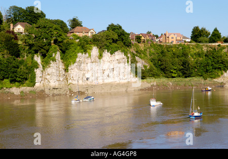 Boote in tidal River Wye unter Klippen mit Einfamilienhäusern in Chepstow Monmouthshire South East Wales UK an der Spitze Stockfoto