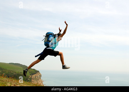 Junges Mädchen scheinbar Sprung von einer Klippe Sarah Klein mit Rucksack Stockfoto