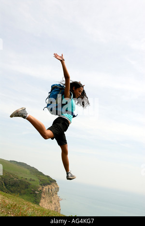 Junges Mädchen scheinbar Sprung von einer Klippe Sarah Klein mit Rucksack Stockfoto