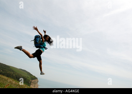 Junges Mädchen scheinbar Sprung von einer Klippe Sarah Klein mit Rucksack Stockfoto