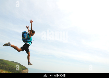 Junges Mädchen scheinbar Sprung von einer Klippe Sarah Klein mit Rucksack Stockfoto