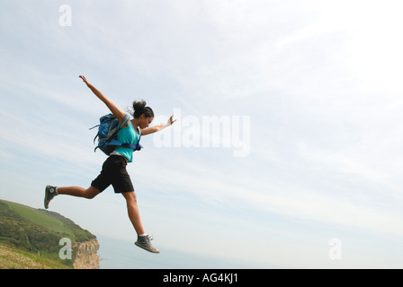 Junges Mädchen scheinbar Sprung von einer Klippe Sarah Klein mit Rucksack Stockfoto