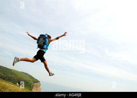 Junges Mädchen scheinbar Sprung von einer Klippe Sarah Klein mit Rucksack Stockfoto