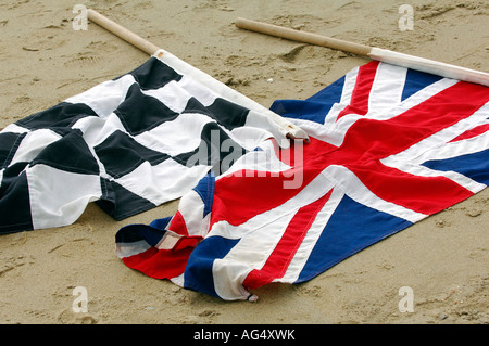 eine Zielflagge und Union Jack-Flagge auf dem Boden Sand am Strand liegen Stockfoto