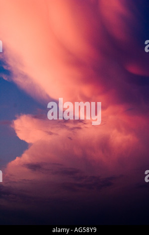 Leuchtende und farbenfrohe fantastische Wolken an einem dramatischen Sonnenuntergangshimmel mit Rosa-, Orange- und Lila-Tönen. Stockfoto