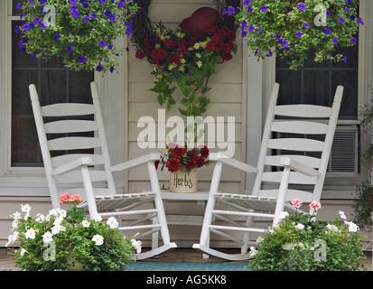 Weißen Schaukelstühle auf Blume bedeckt Cottage Porch Georgetown Indiana Stockfoto