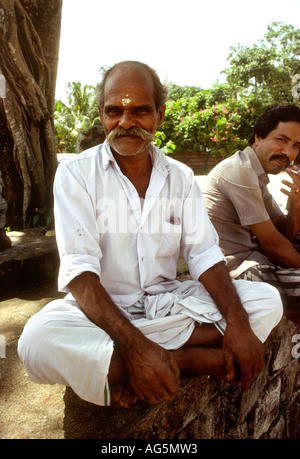 Indien-Kerala-Alleppey Religion Mann sitzt außerhalb Hindu-Tempel Stockfoto