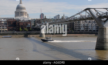 Ein Fluss-Polizei-Boot beschleunigt der Themse unter dem Millenium Bridge St Paul s Cathedral im Hintergrund der Londoner City Stockfoto