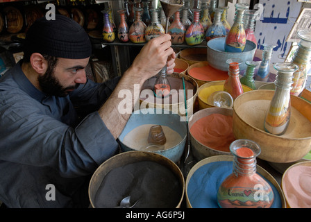 Jordanische Mann fügt farbige Sand eine dekorierte Flasche mit bunten Sand Felsen gefüllt, die in Petra in einem Souvenirshop in Amman Jordanien gefunden wird Stockfoto