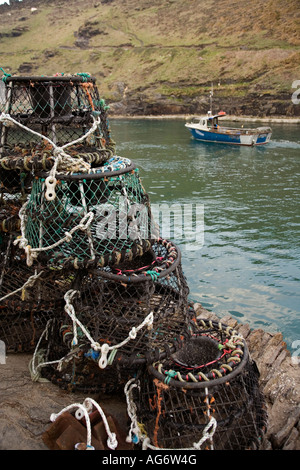 UK Cornwall Boscastle Hafen Lobster Töpfen auf Kai als Boot fährt bei Flut Stockfoto