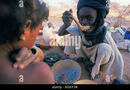 Niger in der Nähe von Agadez Kinder der Wodaabe Stamm Essen mit Holzlöffel Stockfoto