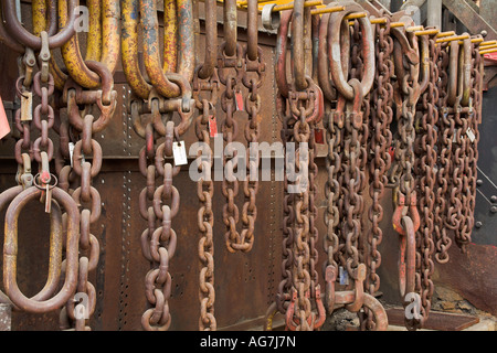 alte rustikale Ketten und Kupplungen hängen in einem verlassenen historische Eisenbahn-workshop Stockfoto