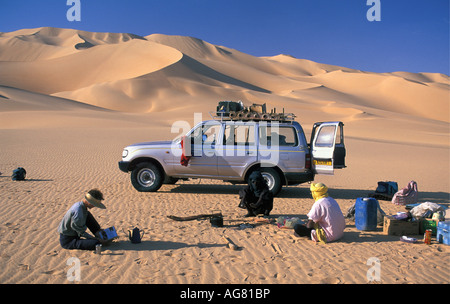 Niger Agadez Touristen und lokalen Anleitung entspannend, Wüste mit 4 x 4 Auto im Hintergrund Stockfoto