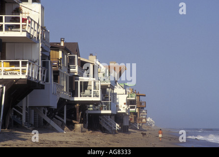 California Malibu private Häuser auf Stelzen am Strand Mann mit Hund Strand entlang läuft Stockfoto
