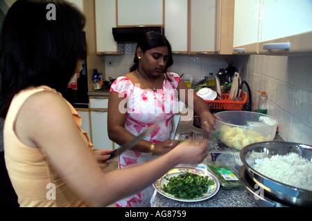 Zwei Mädchen kochen eine Familie Mahlzeit in der Küche Stockfoto