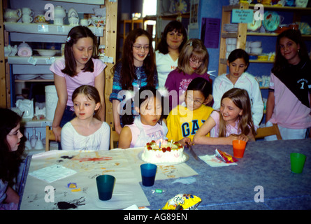 Elf Jahre altes chinesisches Mädchen Ausblasen der Kerzen auf Kuchen auf Geburtstagsparty Stockfoto