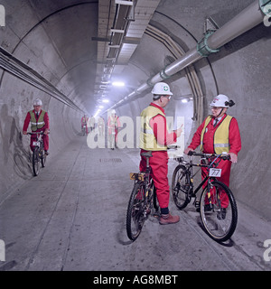 Eurotunnel-Ingenieure mit Fahrrädern zu viele Meilen pro Tag Qualitätsüberwachung Work In Progress in der Kanaltunnel abdecken. Stockfoto