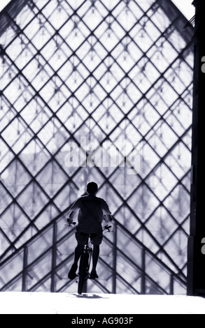 Louvre-Pyramide & Teenager Radfahren Stockfoto