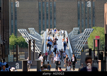 Fußgänger, die ihren Weg über die Millennium Bridge arbeiten, die zwischen der City of London und die Tate Modern England läuft Stockfoto