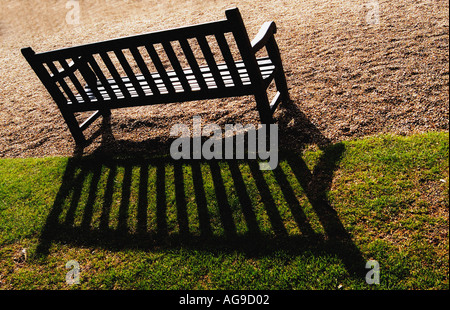 Parkbank mit Schatten Stockfoto