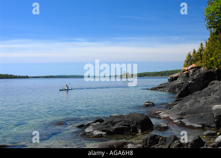 Michigan Kayaker Isle Royale National Park Great Lakes Kajakfahren an felsiger Küste klares, ruhiges Wasser Stockfoto